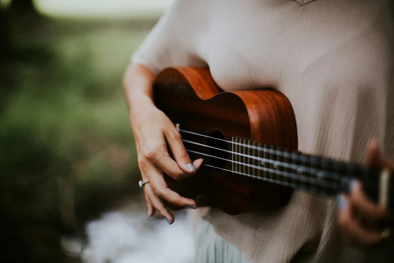 A musician playing a wooden ukulele
